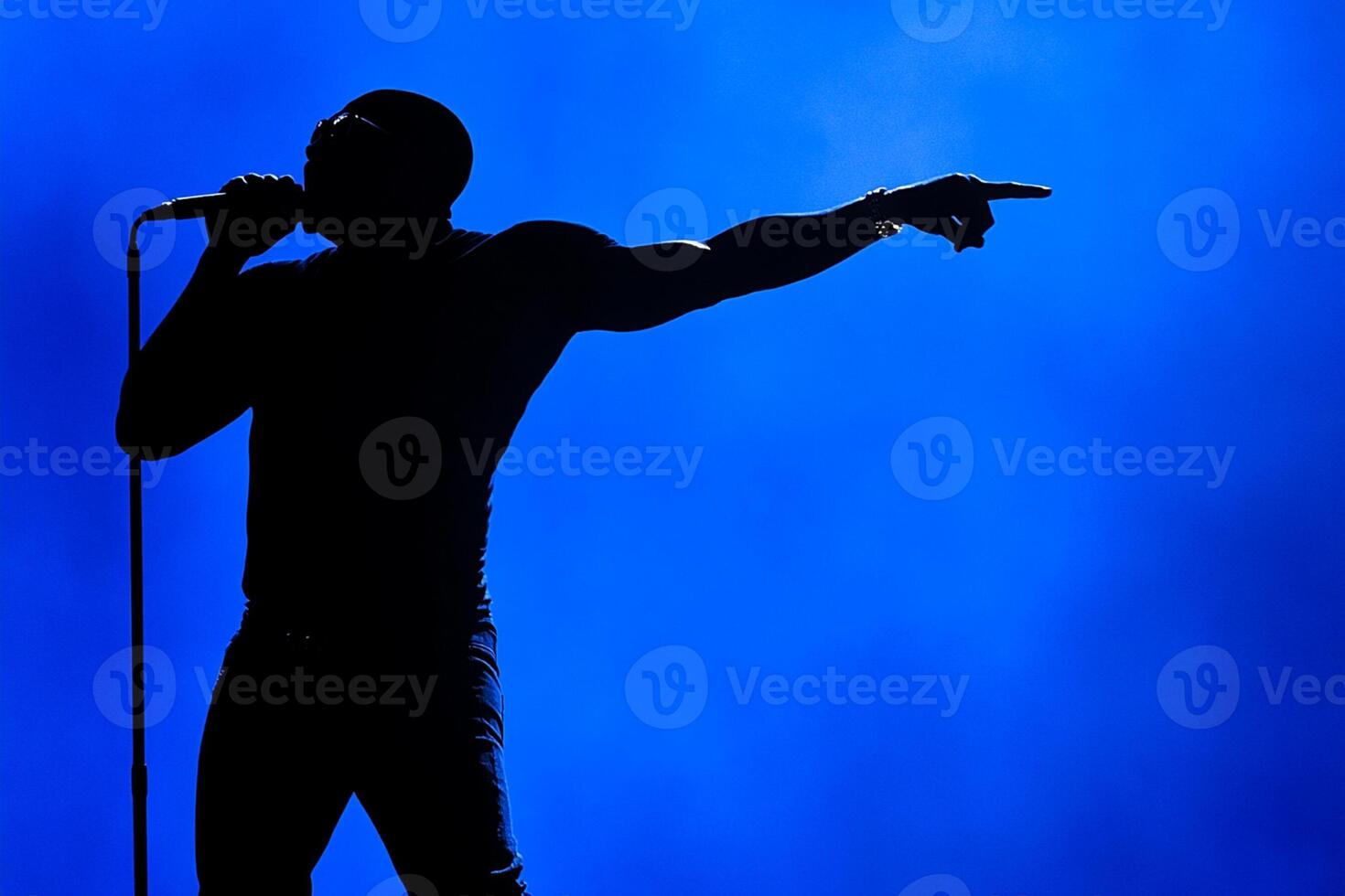 A silhouette of a man in a black shirt on stage photo