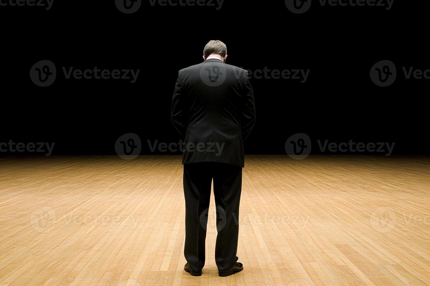 A man in a suit standing in a dark room photo
