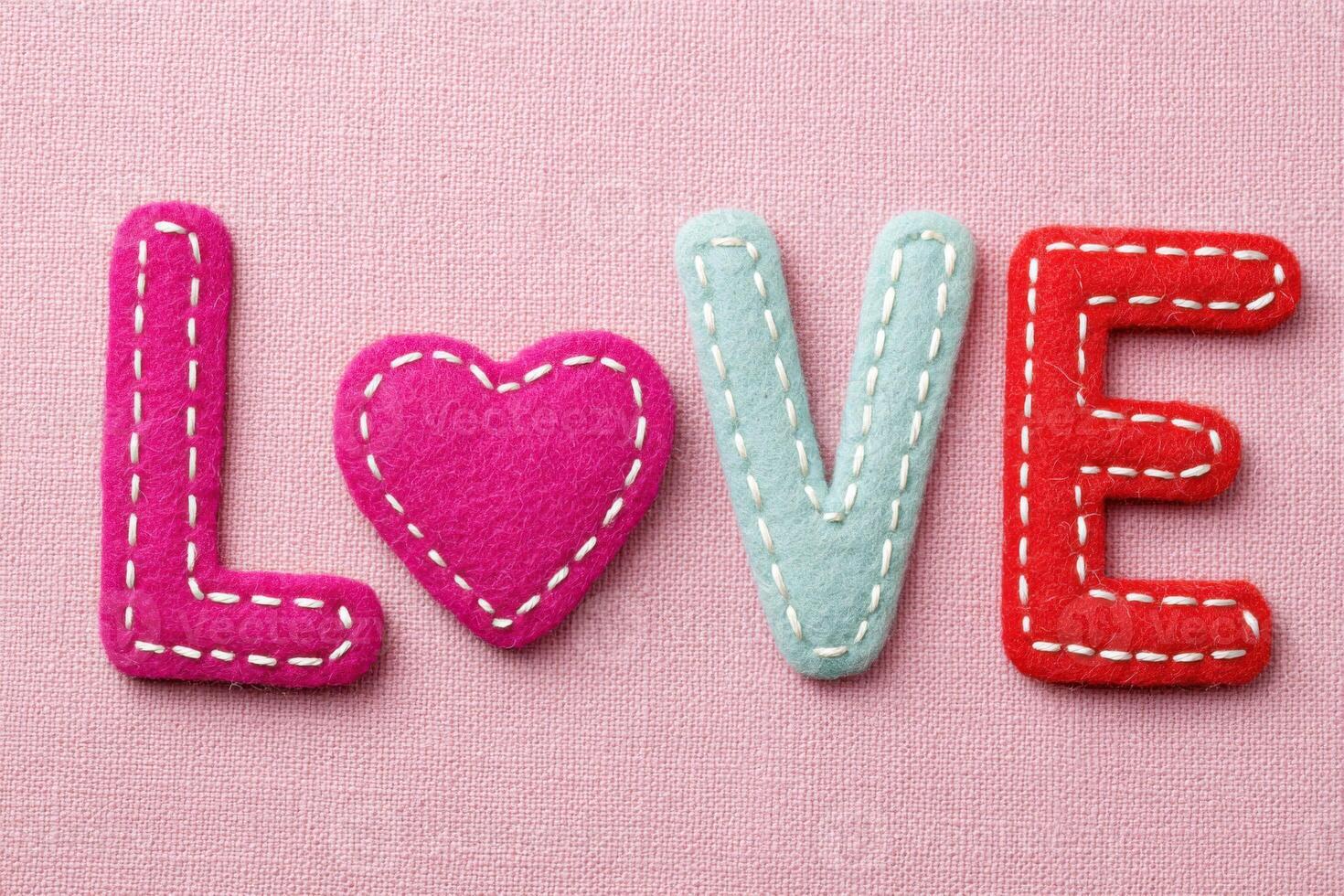Colorful felt letters spelling love with heart replacing the letter o photo