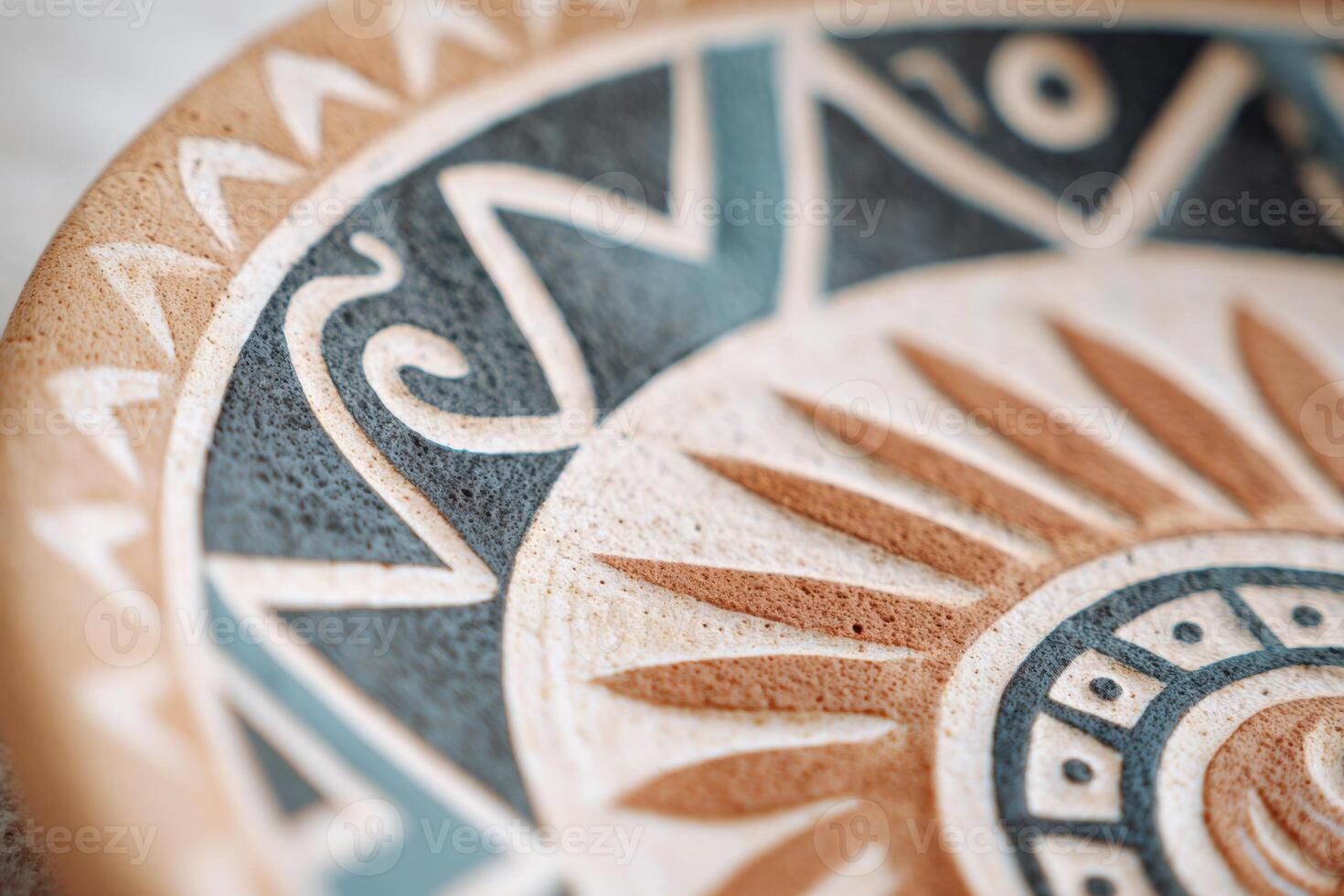 Clay plate featuring intricate Polynesian patterns representing sun and ocean waves photo