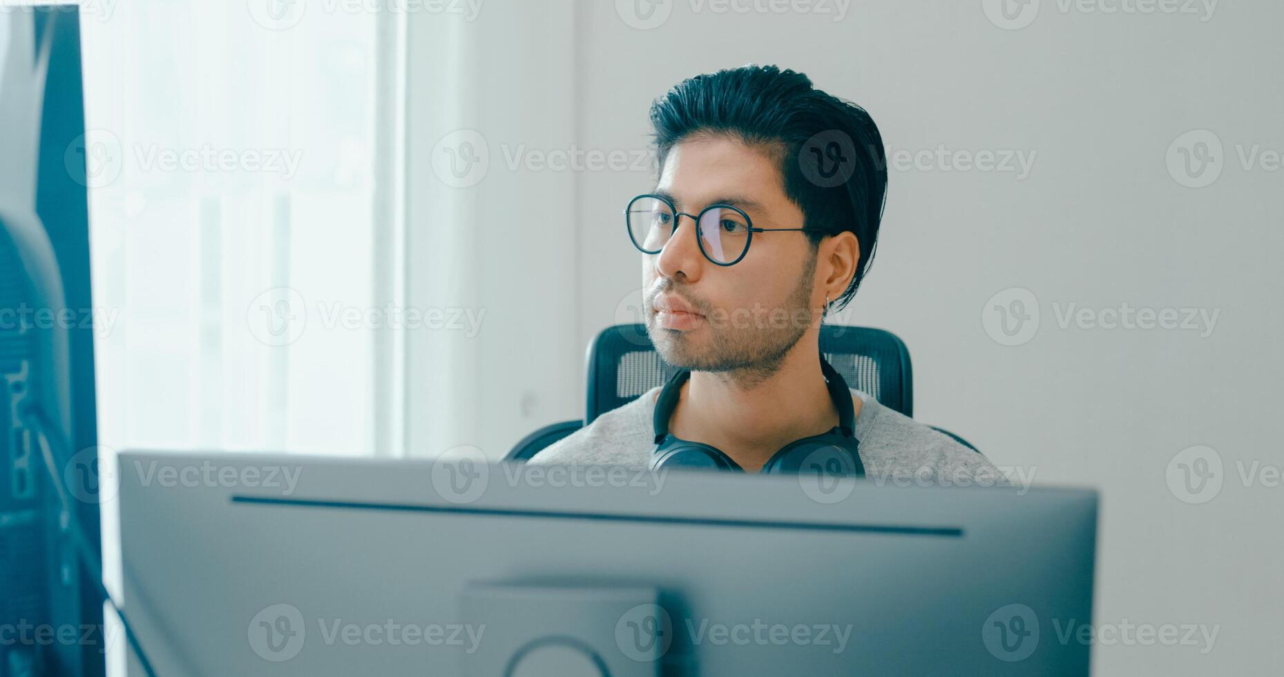 male freelance eyeglasses typing write prompt AI bot IT app smart program nomad, game, terminal with coding, user interface, designer, big data center on desktop computer. photo