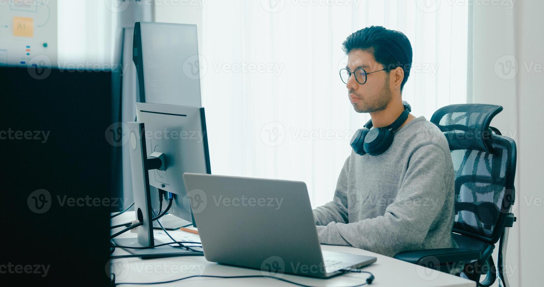 adult Asia male freelance typing write prompt AI bot IT app smart program nomad, game, terminal with coding, user interface, designer, big data center on desktop computer. photo