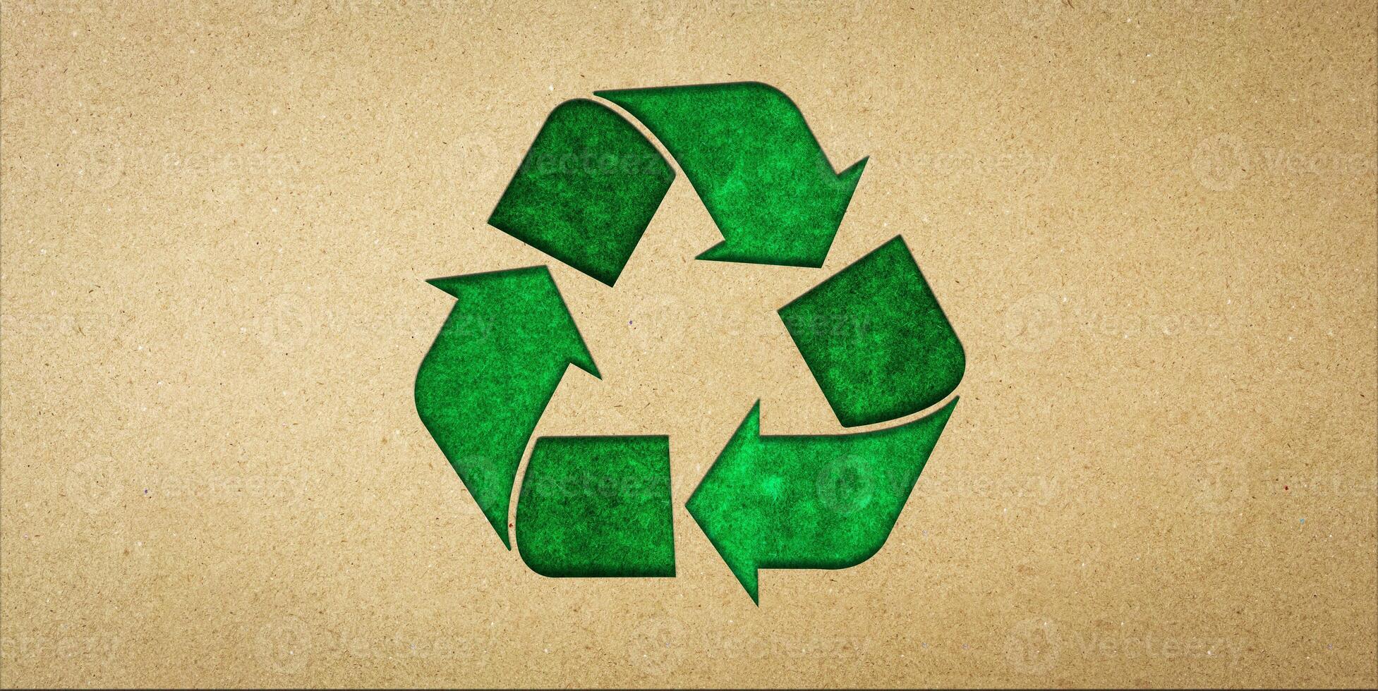 Green recycling symbol on brown paper. Concepts of reducing waste and reusing, symbolism of environmentally friendly products, CSR, zero waste. photo