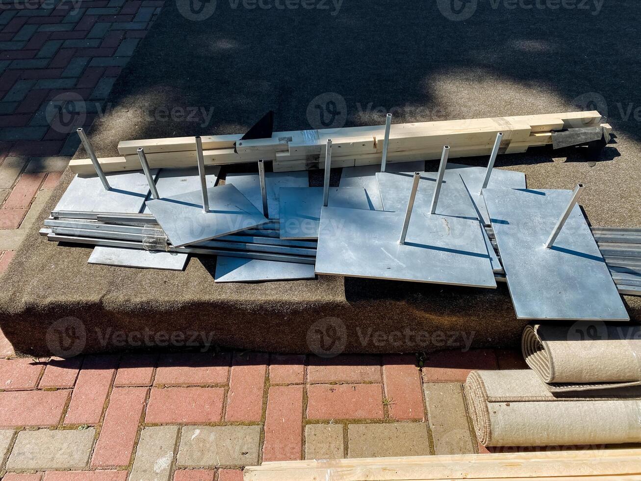 A collection of various metal fragments can be seen scattered across a durable brick sidewalk, creating an interesting contrast between the materials and the surface beneath them photo