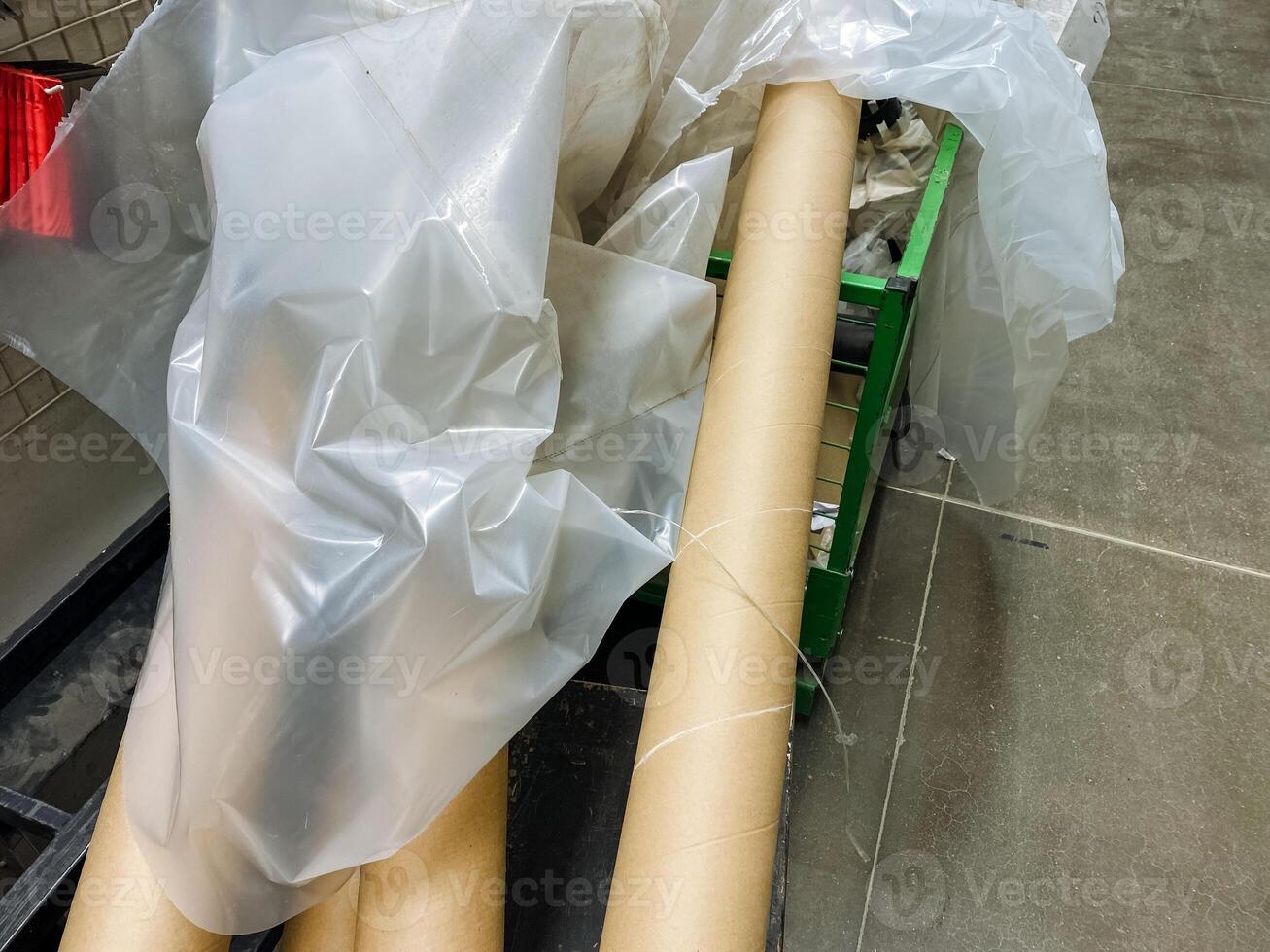 A plastic bag is being wrapped around two cardboard tubes for the purpose of protection and proper organization during the storage or shipping process to ensure safety and cleanliness photo