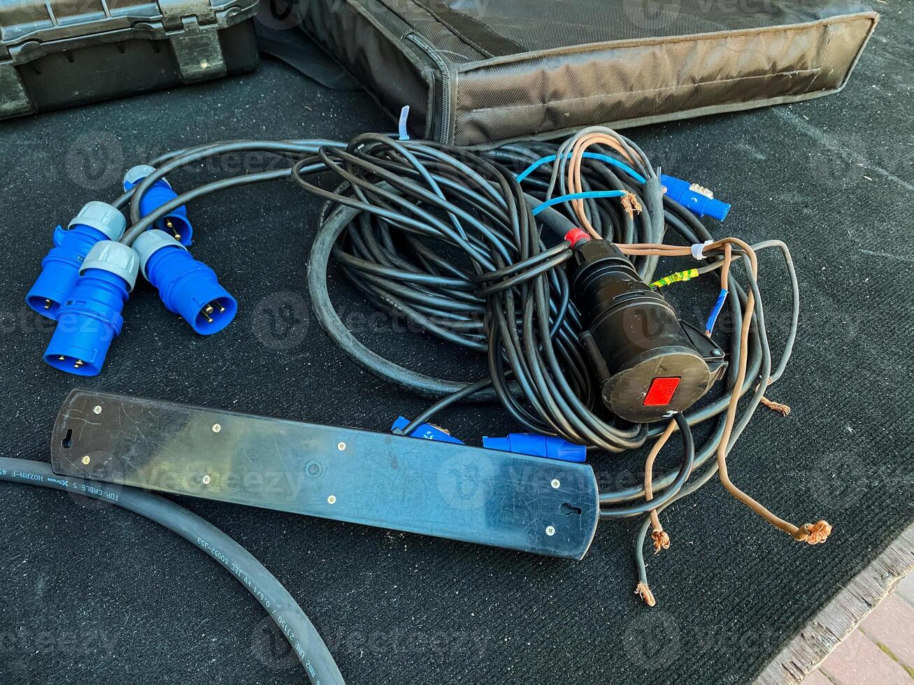 A collection of various wires and electrical cables are currently laying on the ground, creating a tangled mess that could pose potential hazards if not addressed promptly photo