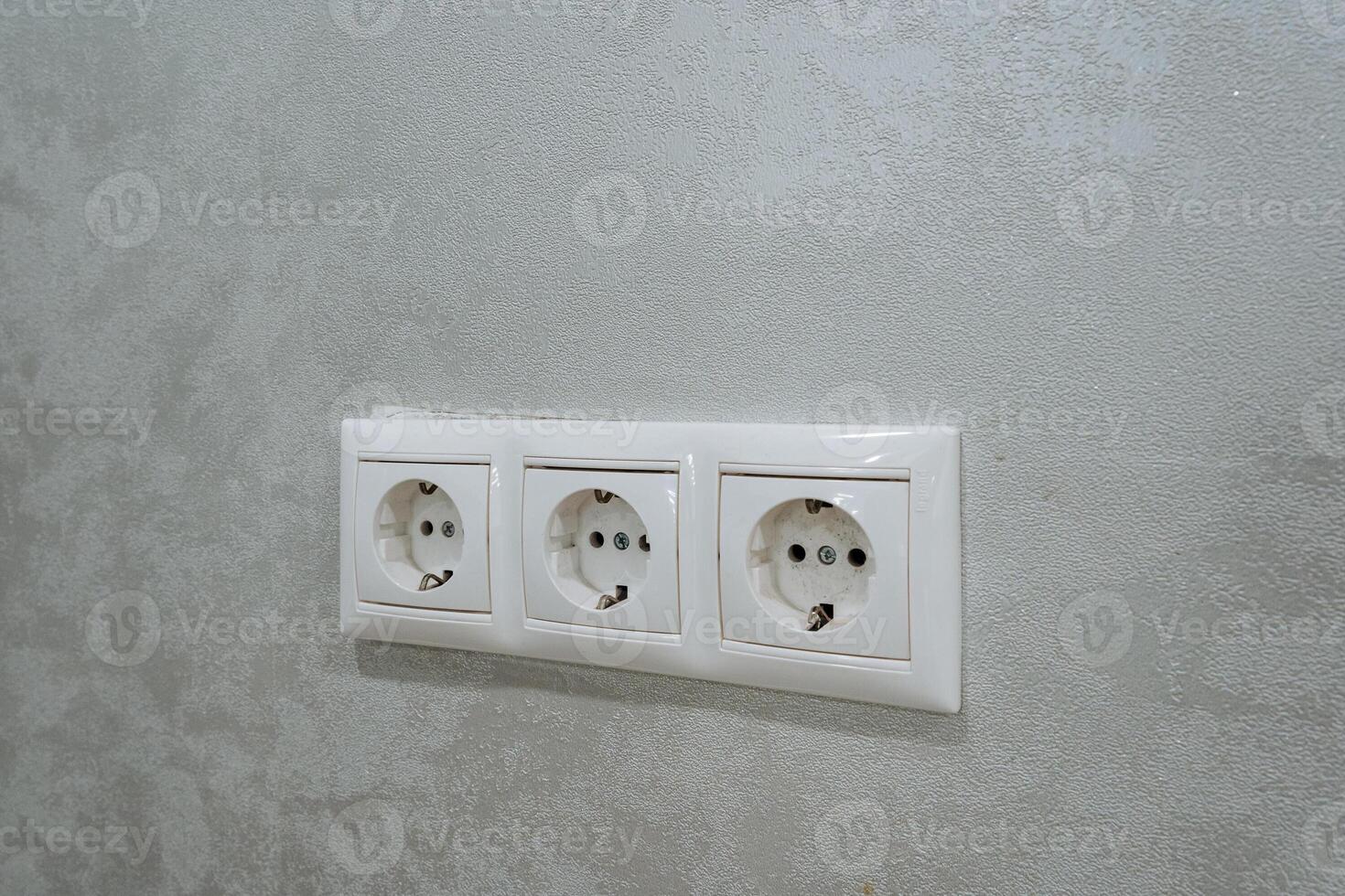 This article discusses the installation of three standard electrical outlets located on a textured wall. It covers aspects like convenience for accessories and appliances in various settings photo