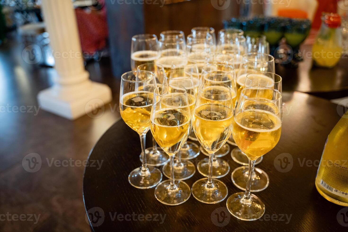 An elegant and beautifully arranged lineup of glasses filled with a sparkling and refreshing beverage, perfect for enhancing celebratory events and gatherings that bring people together in joy photo