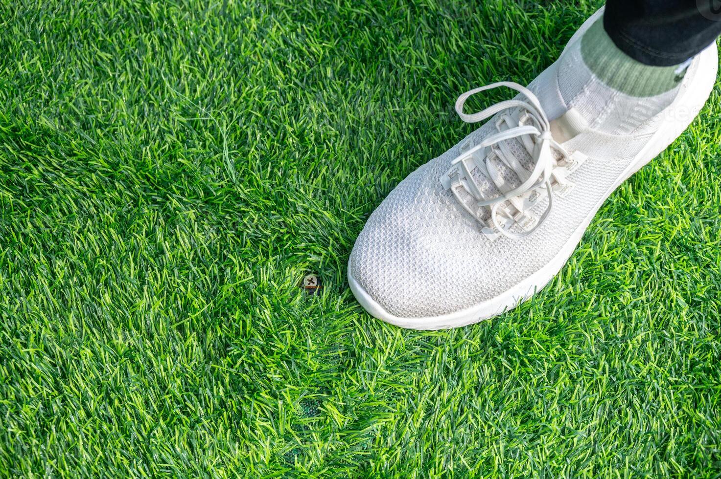 Someone standing on incomplete green artificial turf. photo