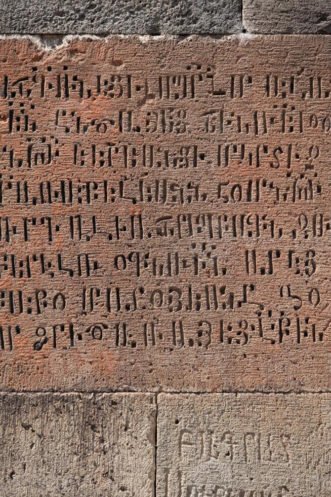 Fragment of the wall of an ancient temple with hieroglyphs, Geghard, Armenia. photo