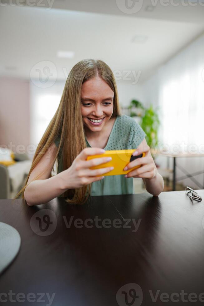 Joyful moment of a young woman engaging with a phone in a bright space photo