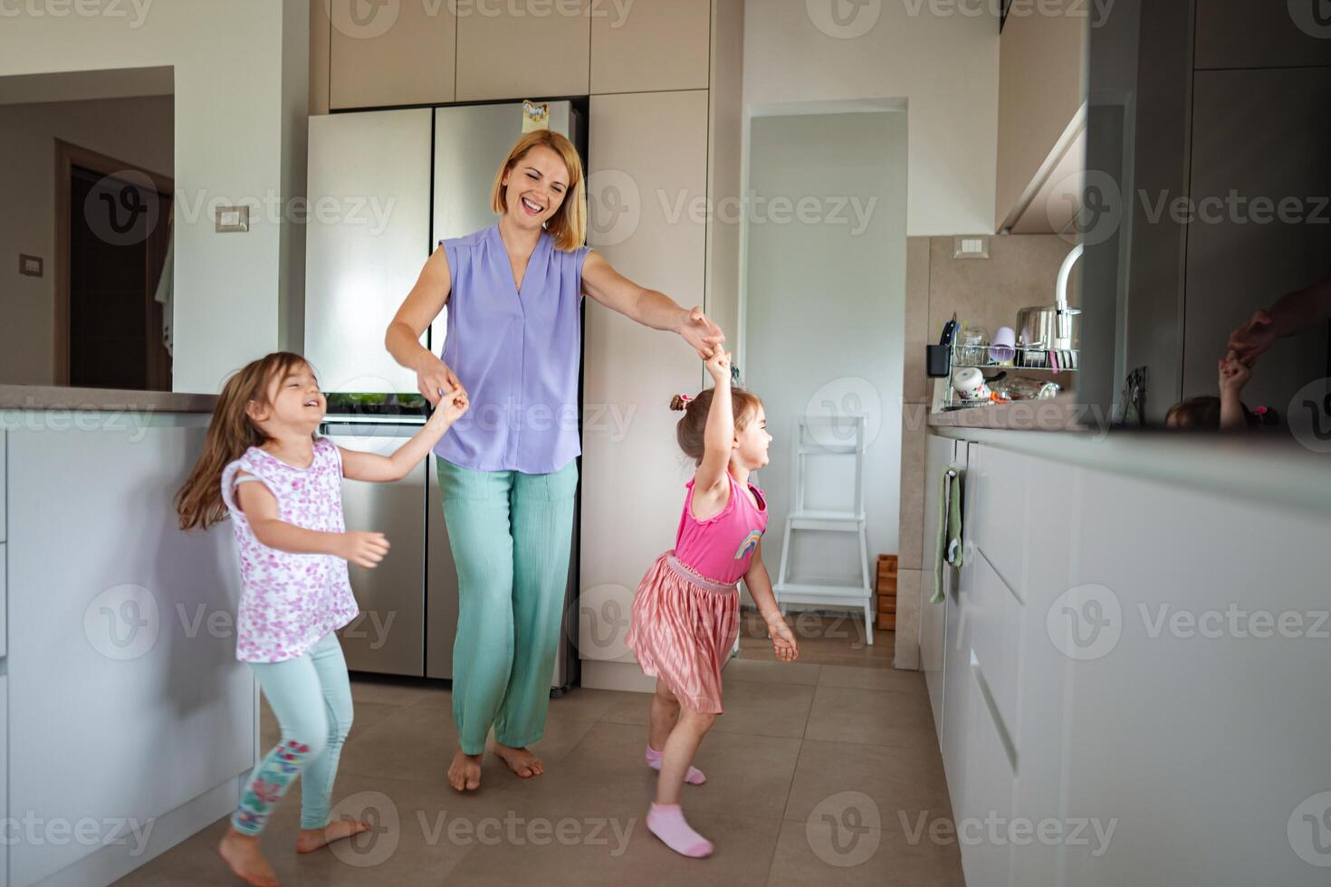 Joyful moments of children dancing in a cozy kitchen photo