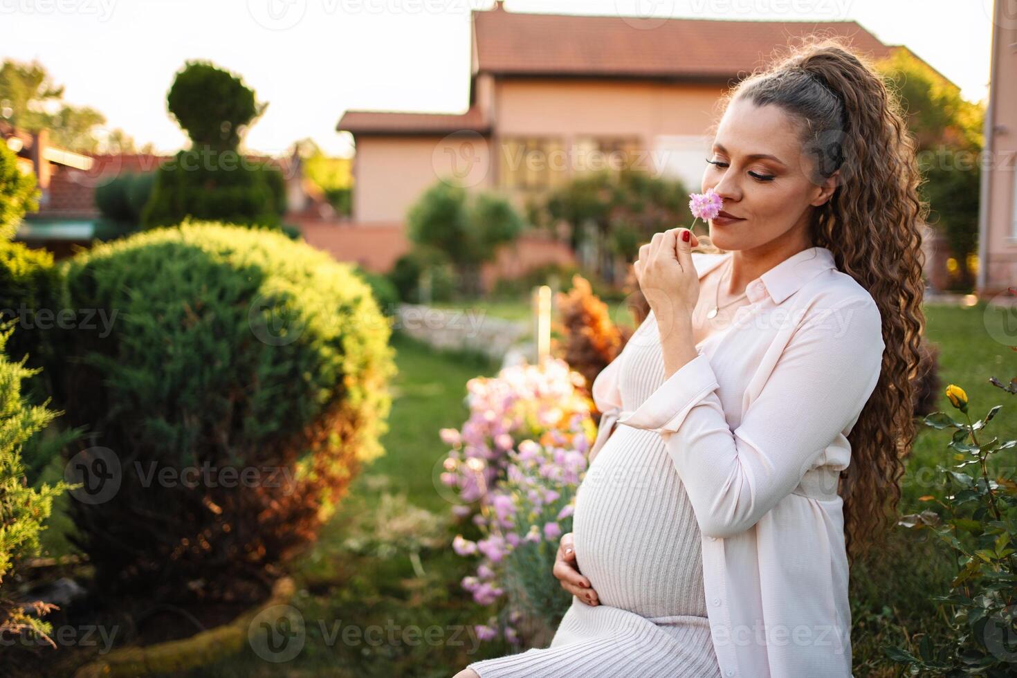 Pregnant woman in a peaceful garden with flowers photo