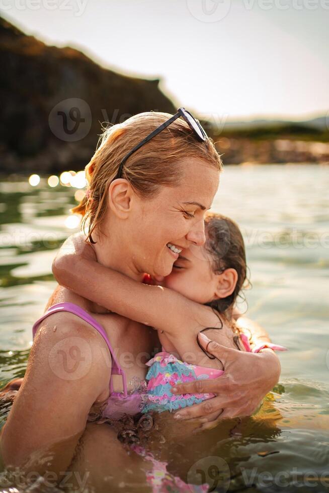 Joyful moments of family bonding at the beach during golden hour photo
