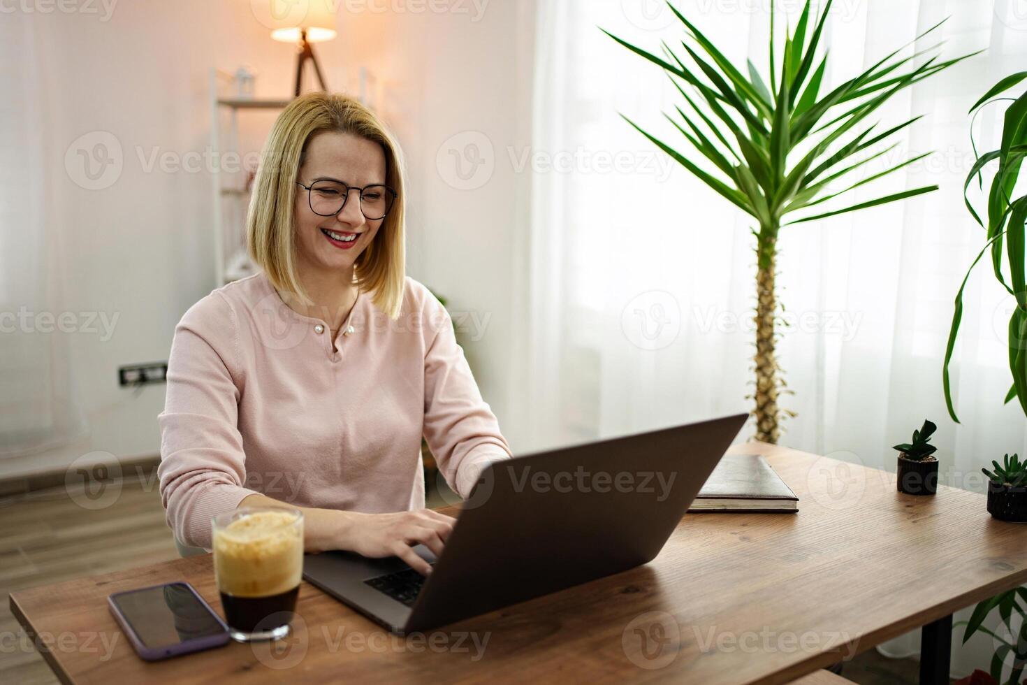 Working happily from home in a cozy environment surrounded by greenery and warm light photo