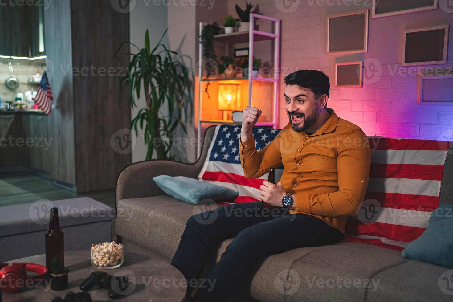 Excitement fills the room as a man celebrates during a game night with friends at home photo