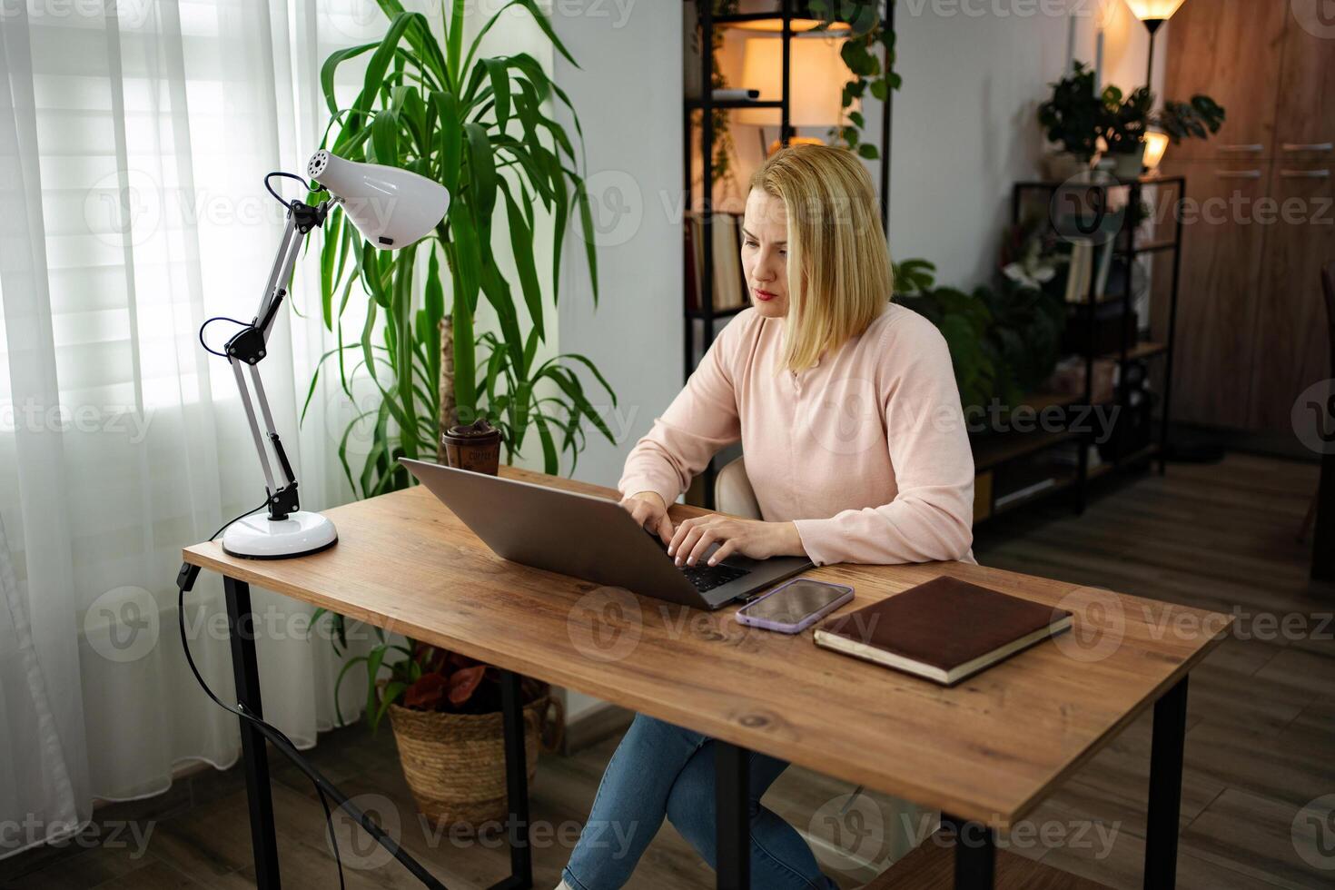 Working from home during the day brings focus and creativity in a cozy indoor workspace filled with greenery photo