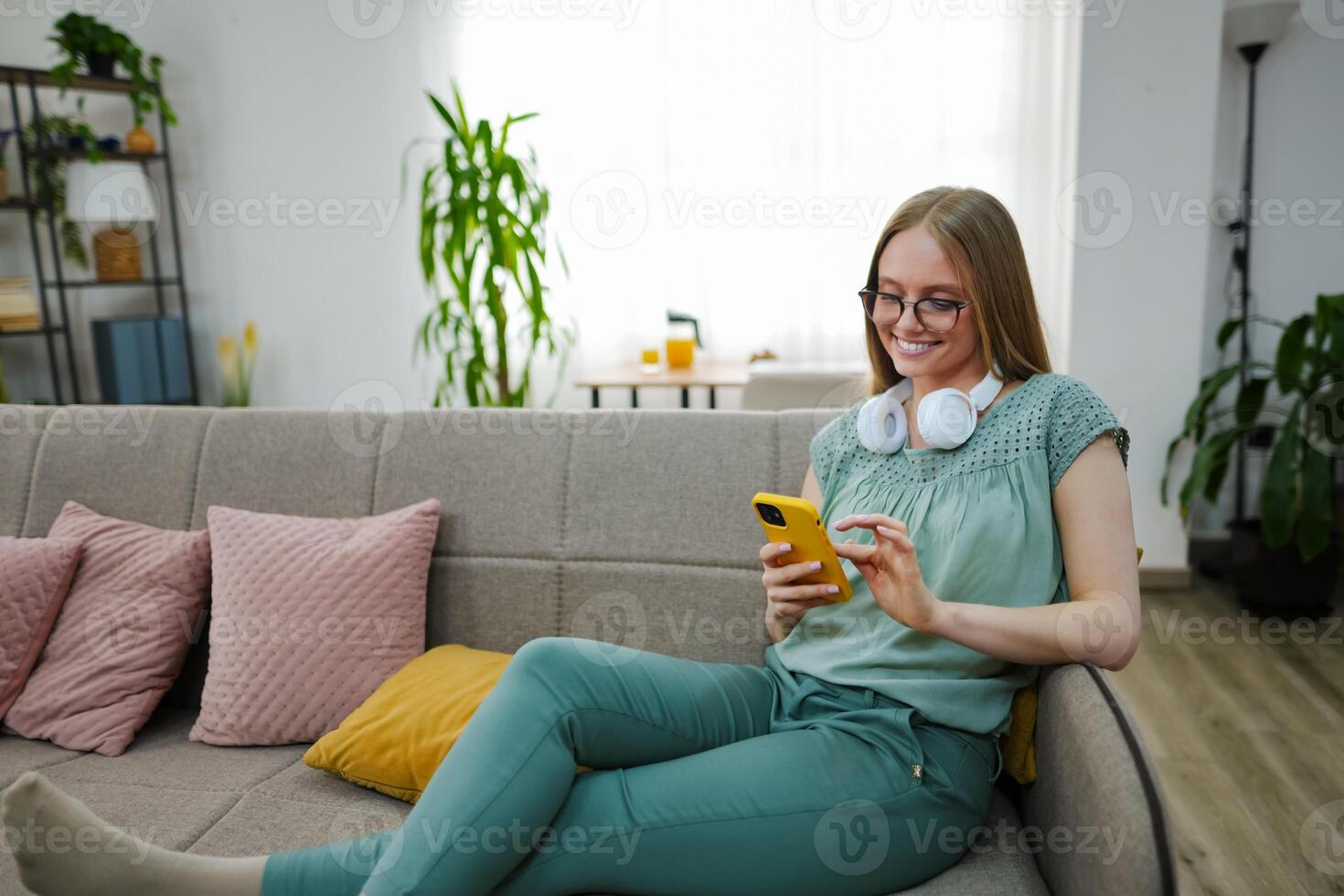 Relaxing at home with a smartphone and headphones in cozy atmosphere photo