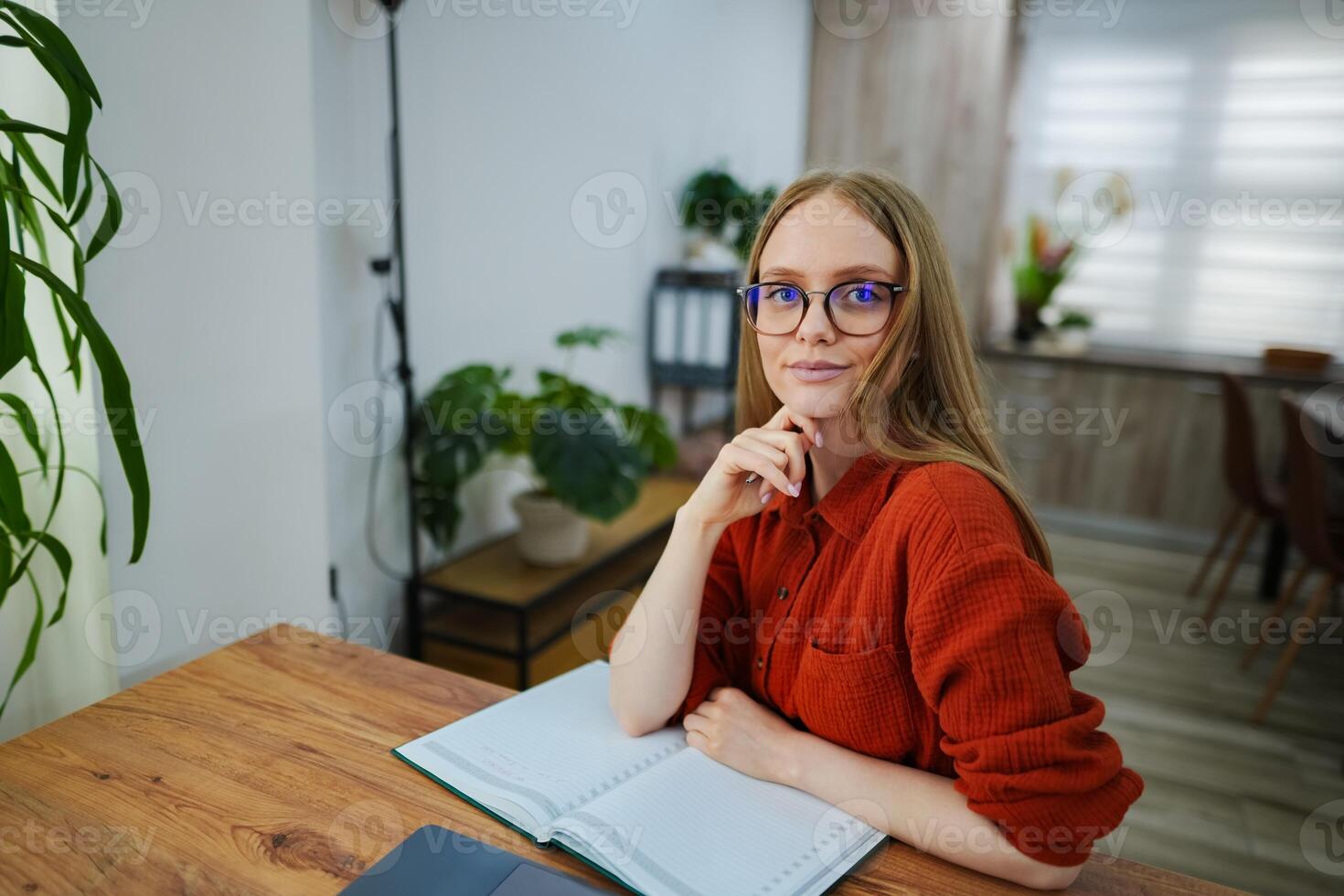 Thoughtful young woman seated in a cozy workspace at home photo