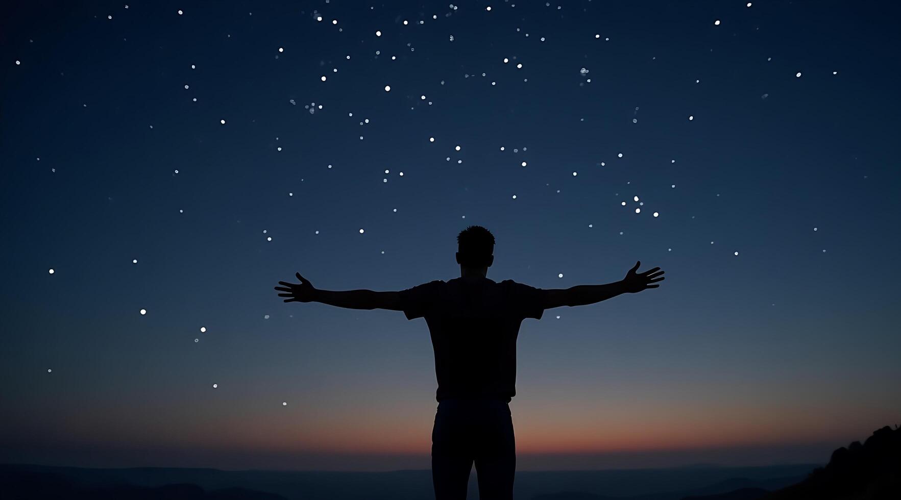 Man standing on top of mountain with his arms outstretched and stars in the sky photo