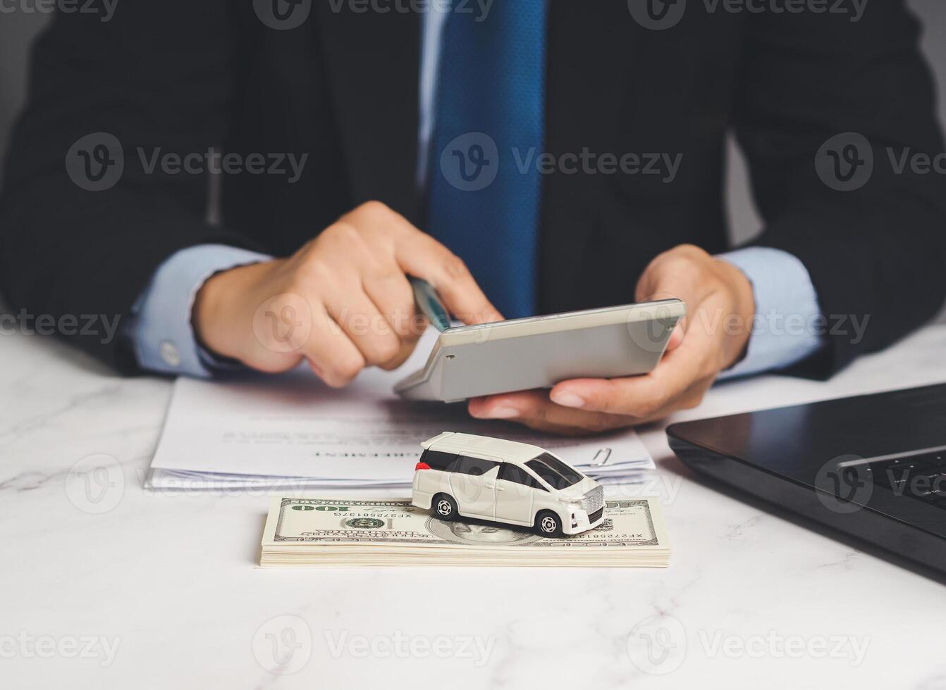 Car loan or Title loan. A Businessman using a calculator while sitting at the table photo