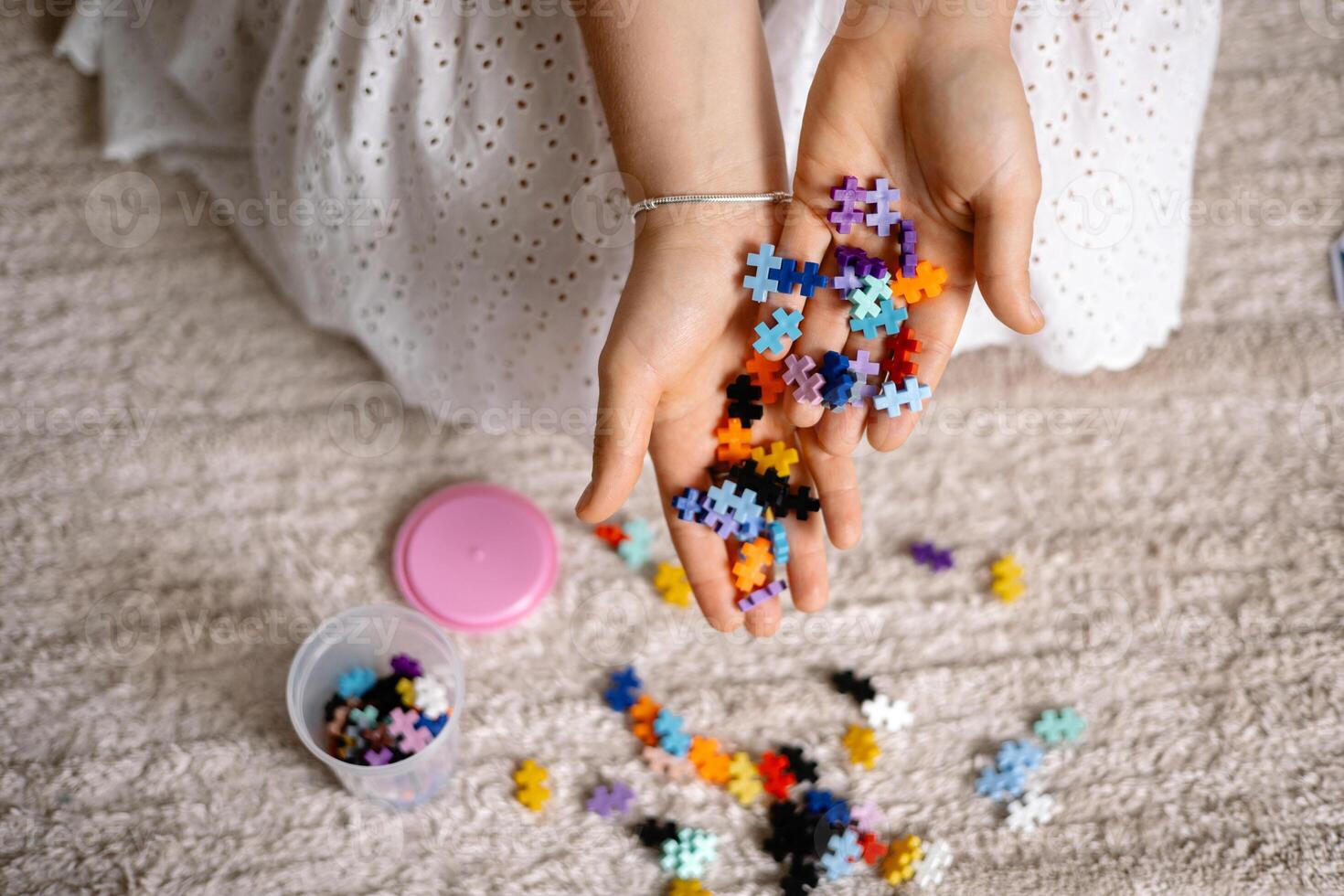 a multi colored small puzzle set in a womans hands. photo