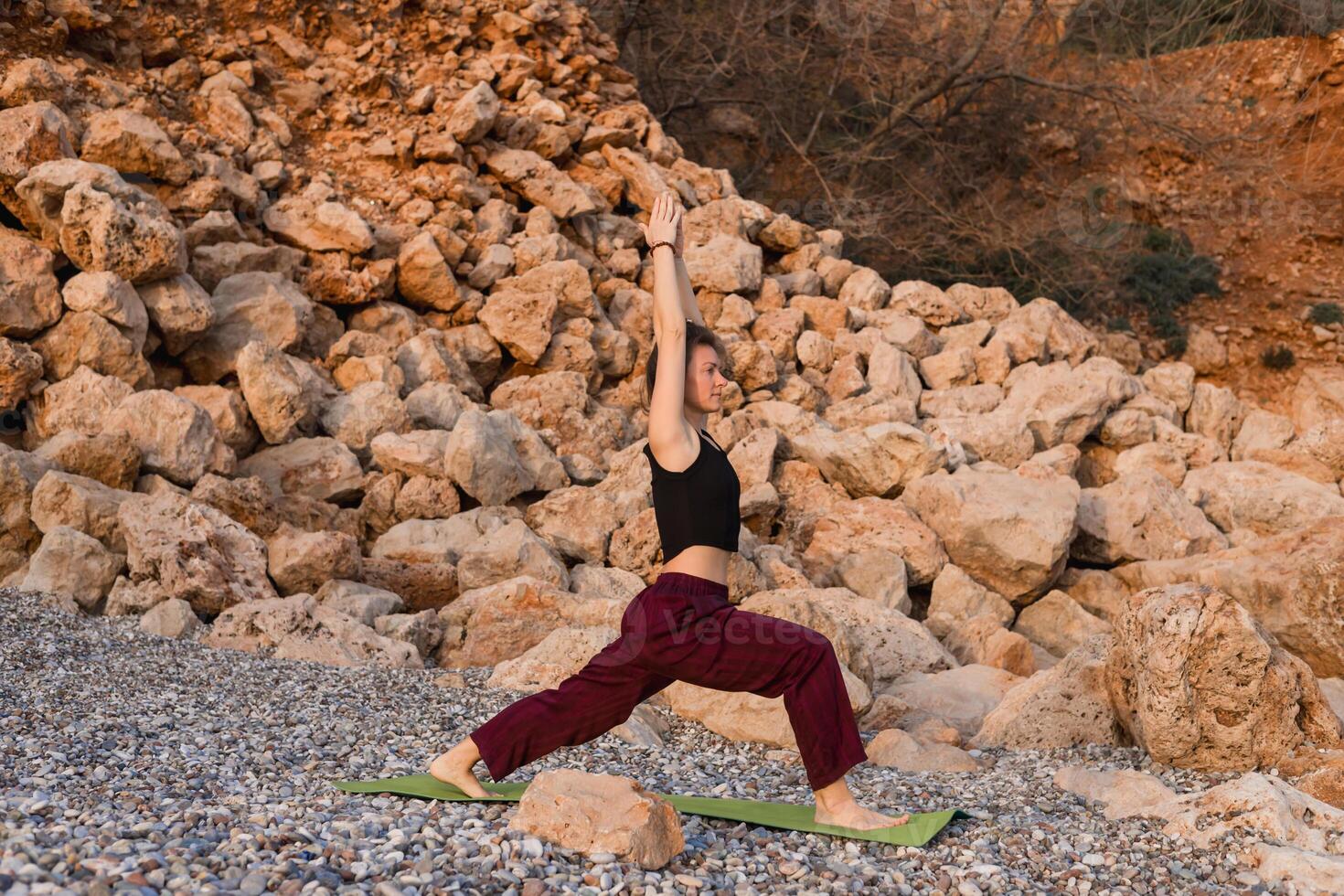 Practicing yoga on calm beach during sunset. photo