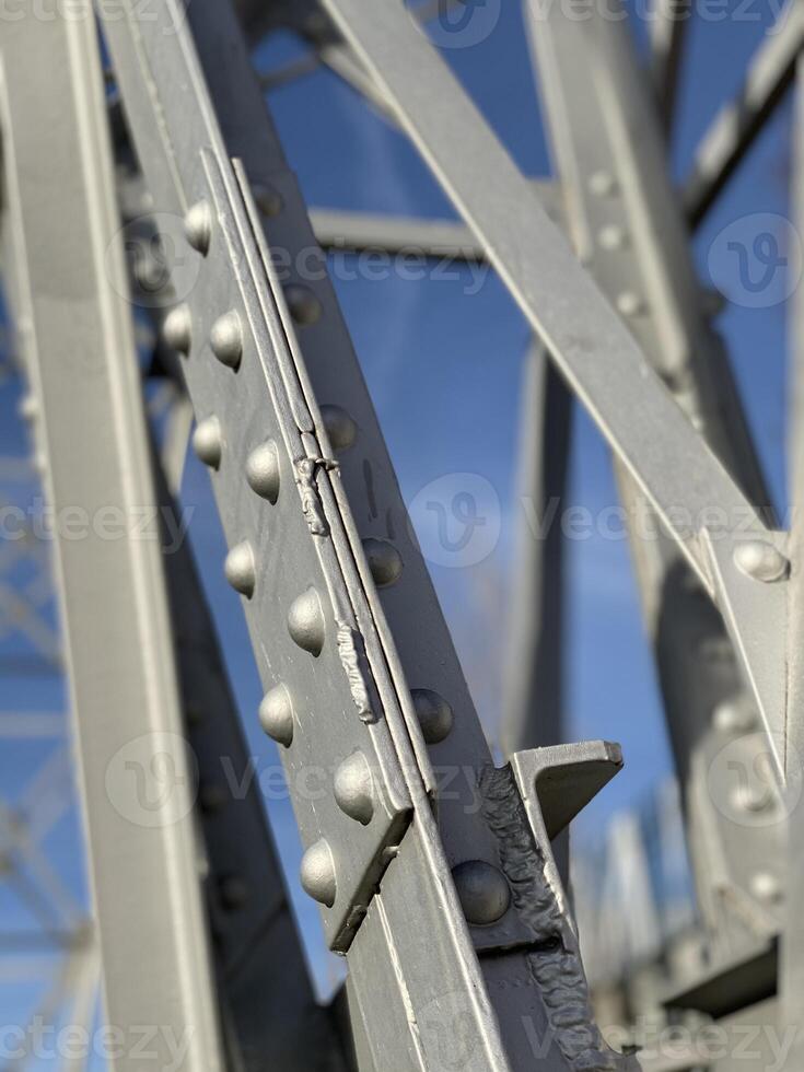 Close up of steel beams with rivets against blue sky, creating an industrial background photo