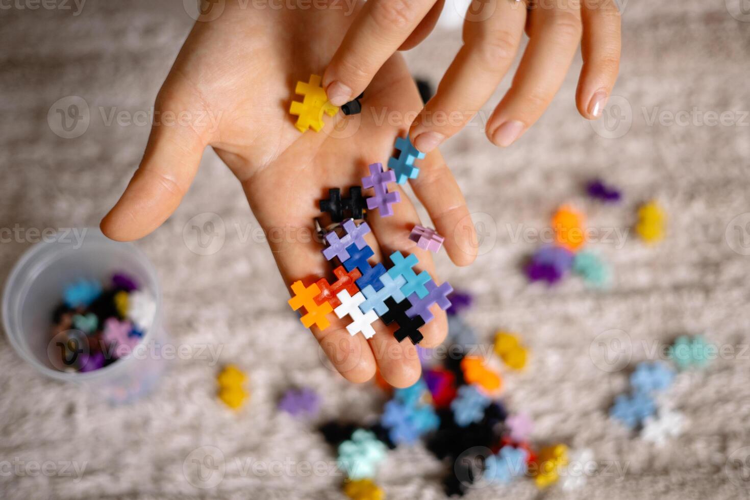 multi colored small puzzle set in a womans hands photo
