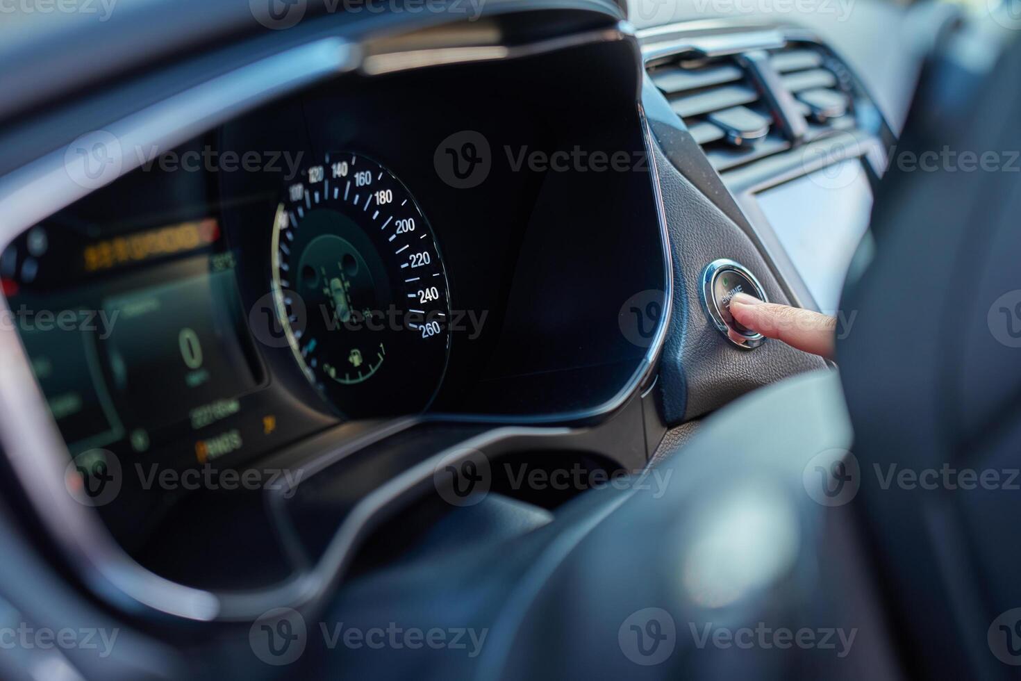 Hand pressing car engine start button inside modern vehicle photo