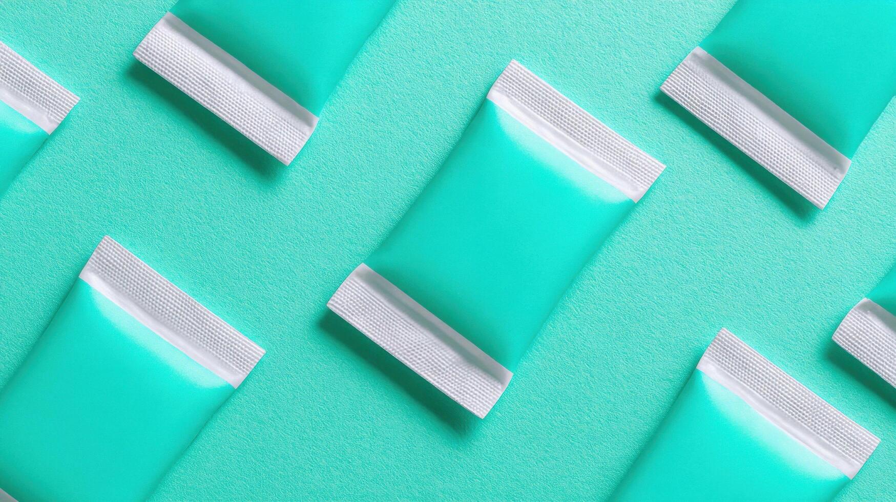 Pattern of teal sachet packets on matching background photo