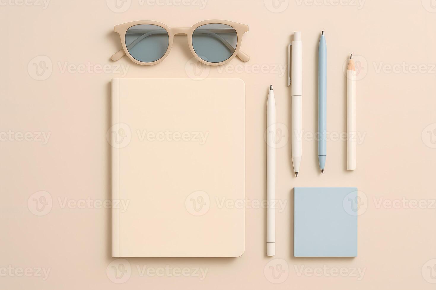 Neutral Toned Stationery Still Life with Notebook Pens Pencil and Sunglasses photo