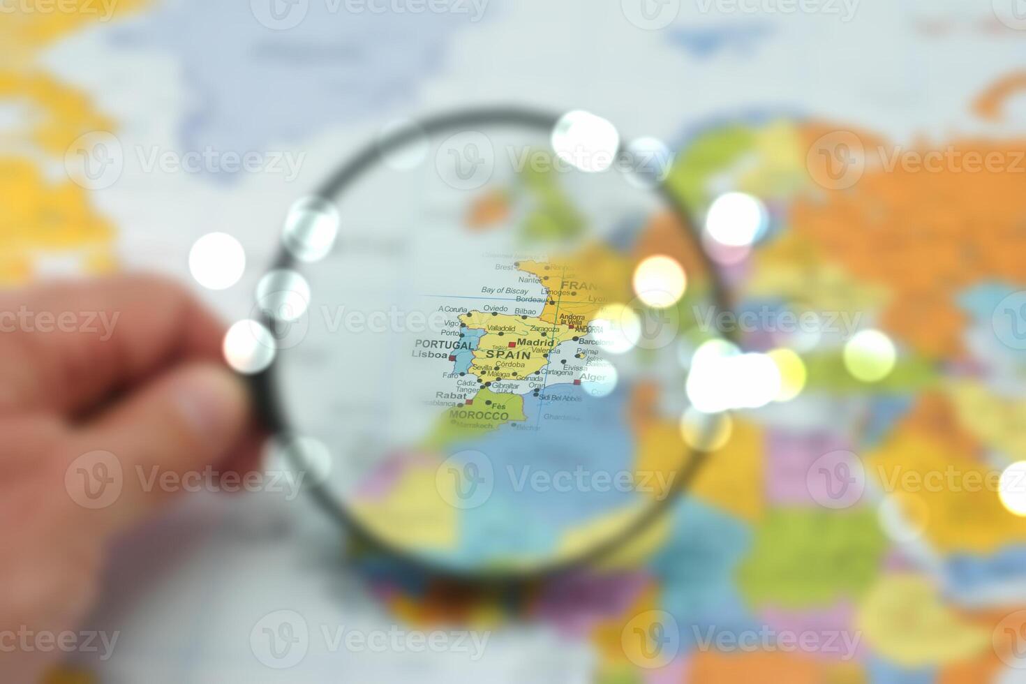 Exploring the detailed map of Spain with a magnifying glass highlighting key locations in Europe photo