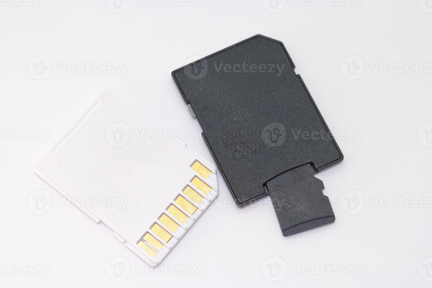 Storage card and adapter on white background for data transfer and memory expansion in electronic devices photo