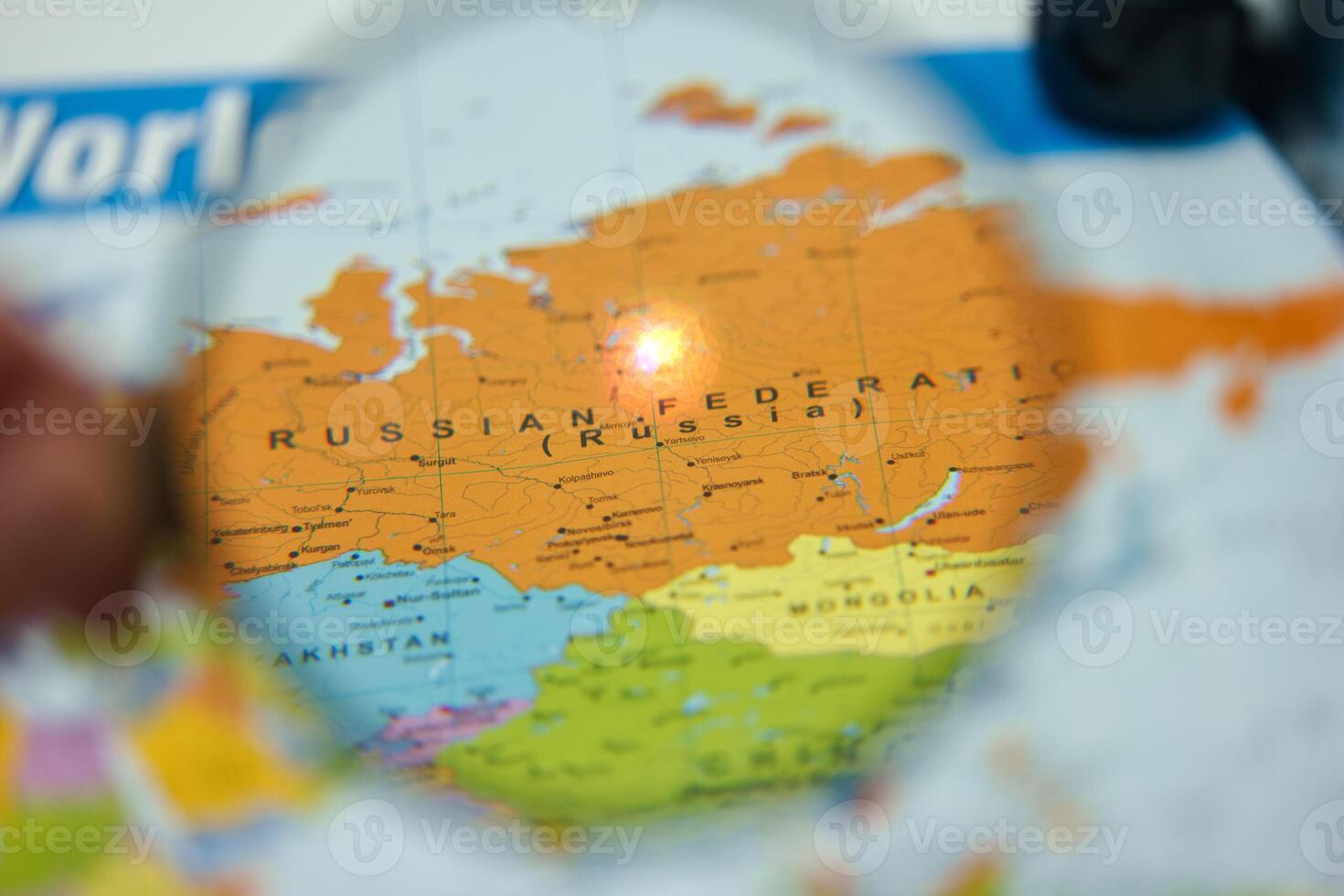 Exploring geographic details of the Russian Federation on a world map with magnifying glass close up photo