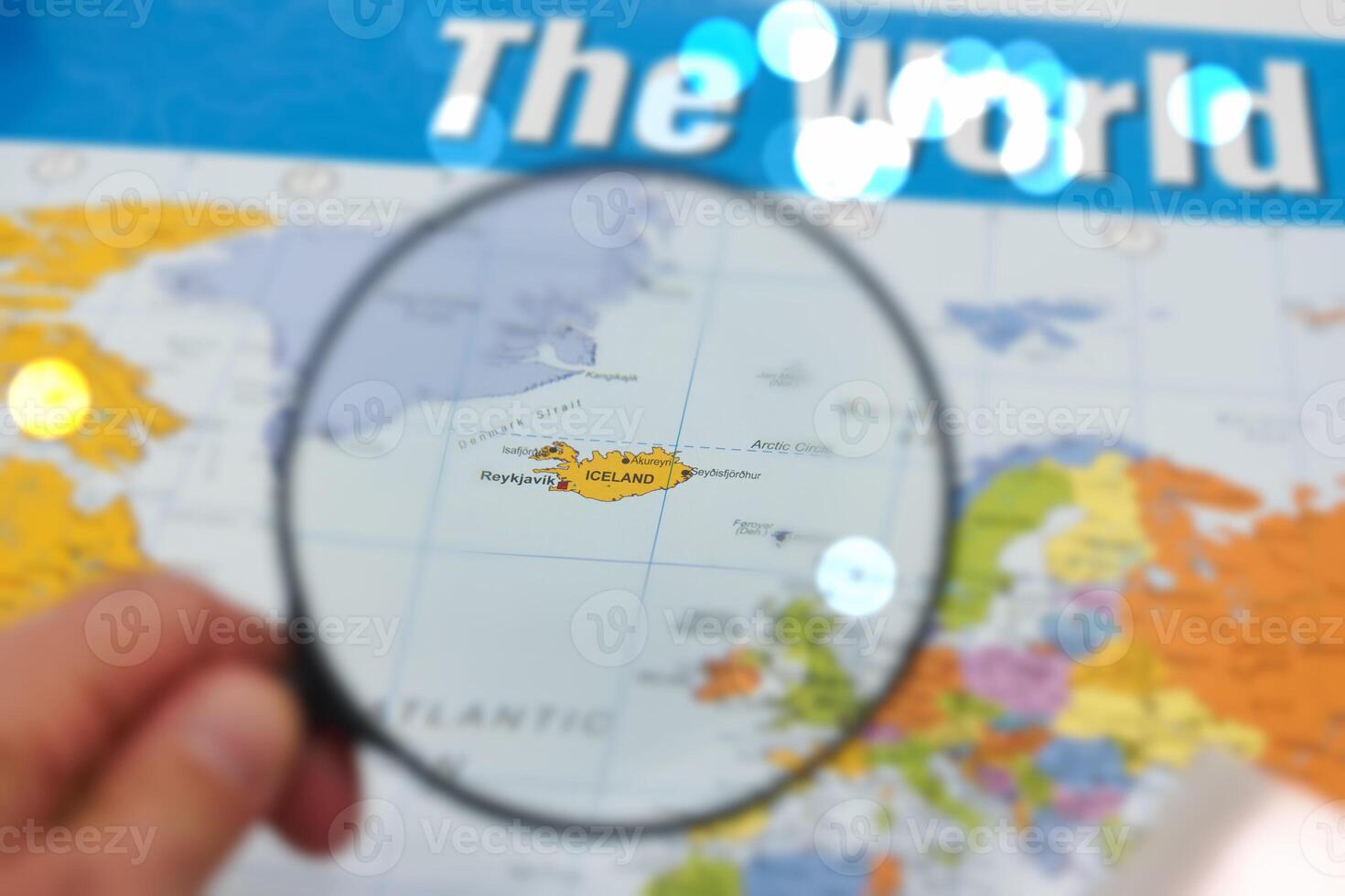 Exploring Iceland on a world map with magnifying glass revealing its unique geographical location photo