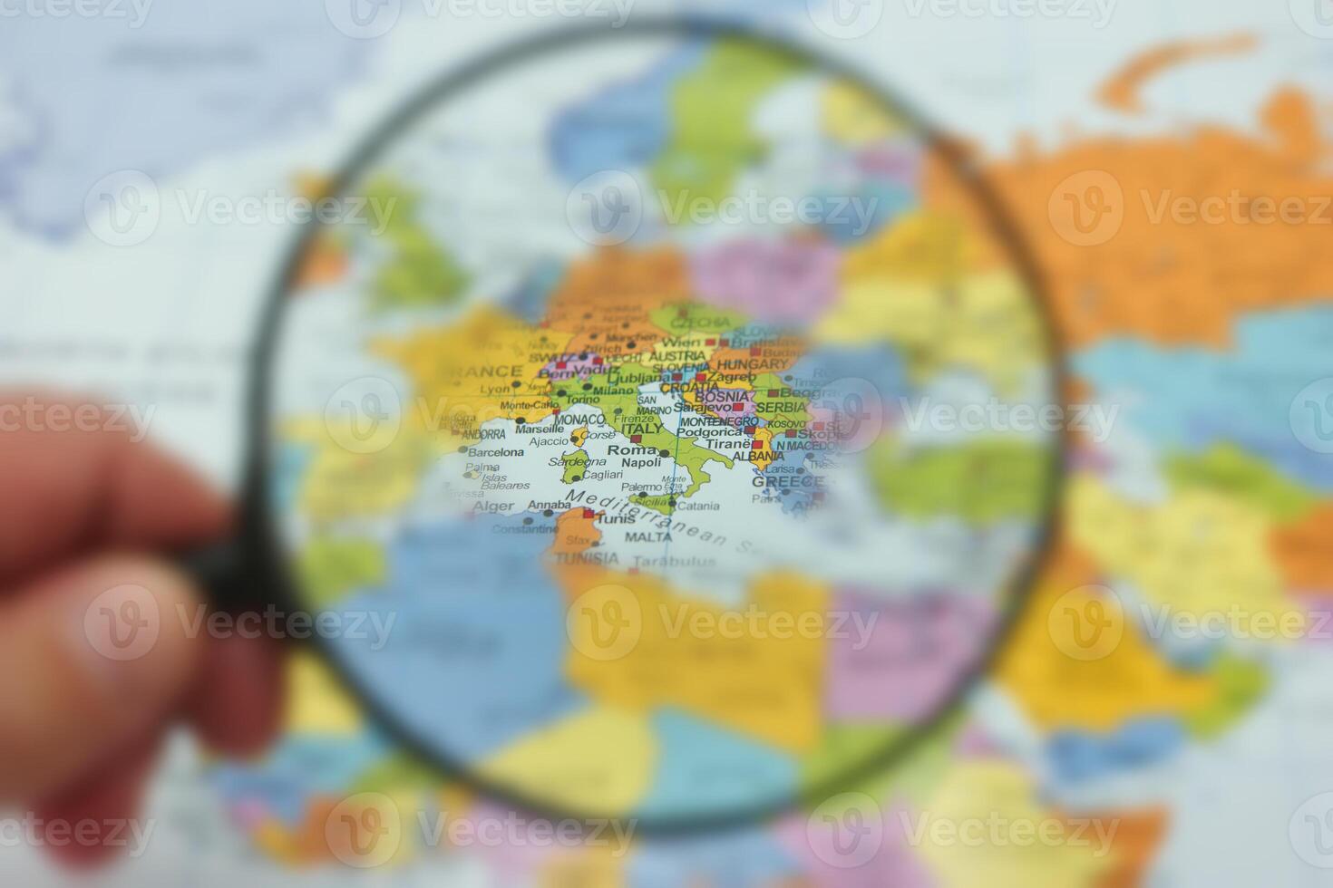 Discovering highlights of Europe through a magnifying glass on a world map photo