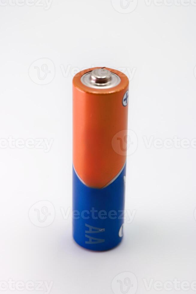 Battery standing upright on a white surface in a well lit setting highlighting its features and colors photo