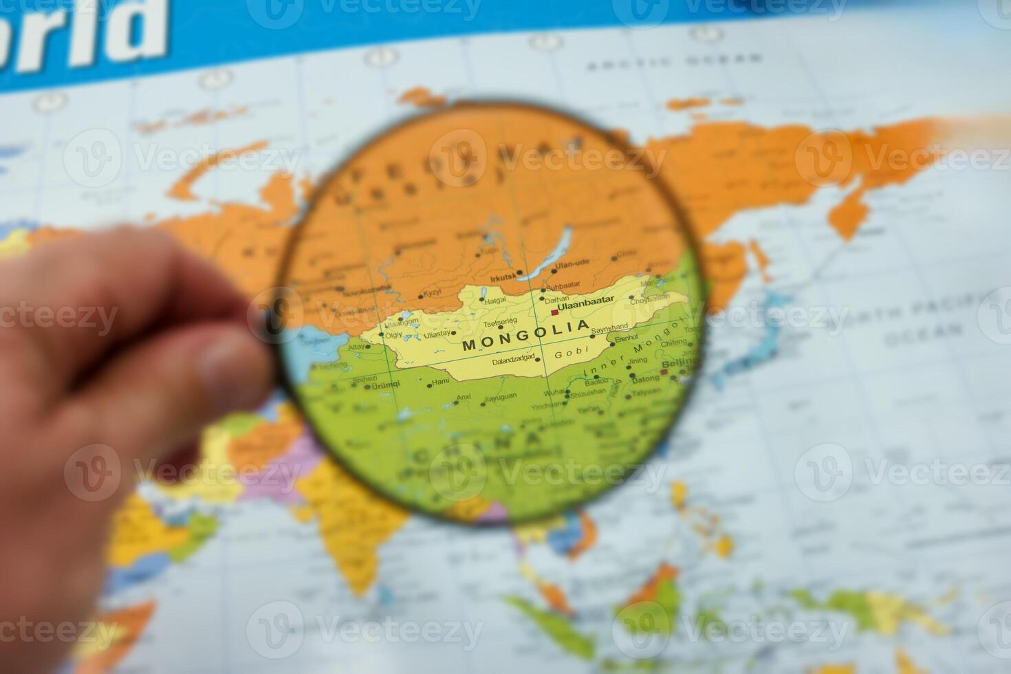 Exploring the geography of Mongolia with a magnifying glass on a world map photo