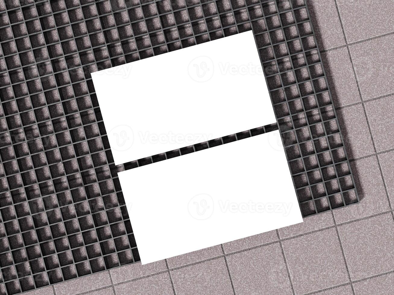White business cards displayed on concrete floor with black gridded surface. photo