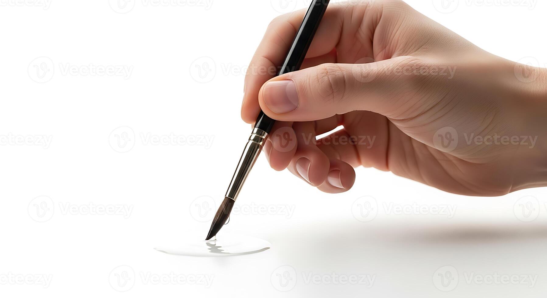 Hand with Paintbrush and Clear Liquid on White Surface photo