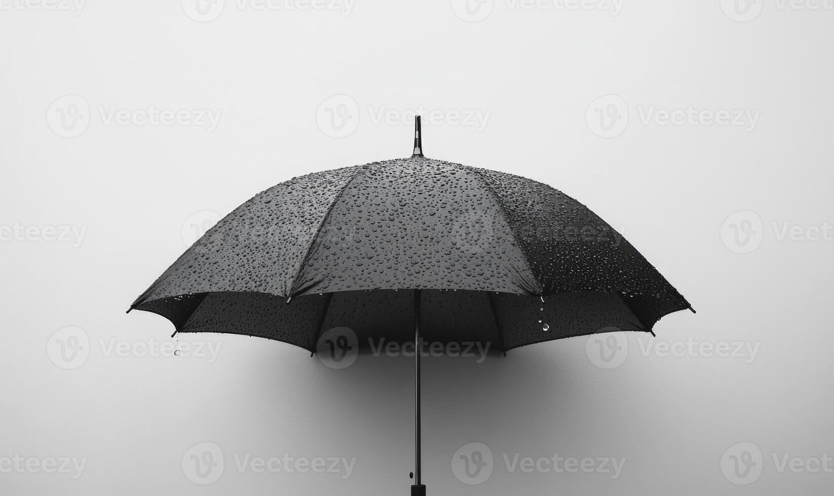 A black umbrella with raindrops, gray wall background photo