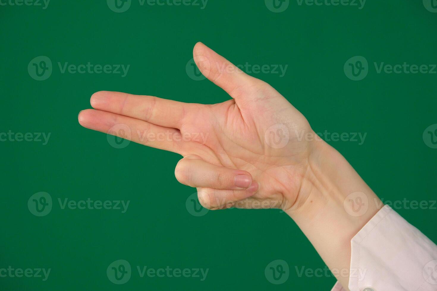 A high-quality image of a human hand making a finger gun gesture against a solid blue background. symbolize shooting, targeting, or action related themes photo