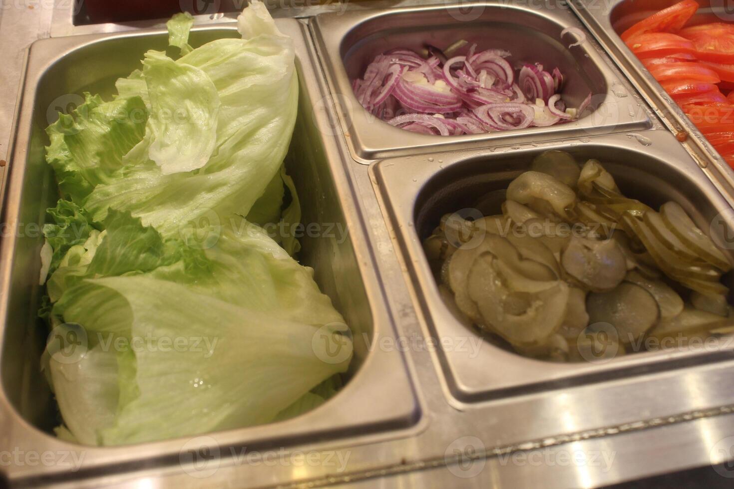 Onions and pickled cucumbers, salad in gastronomic containers. Fast food preparation photo