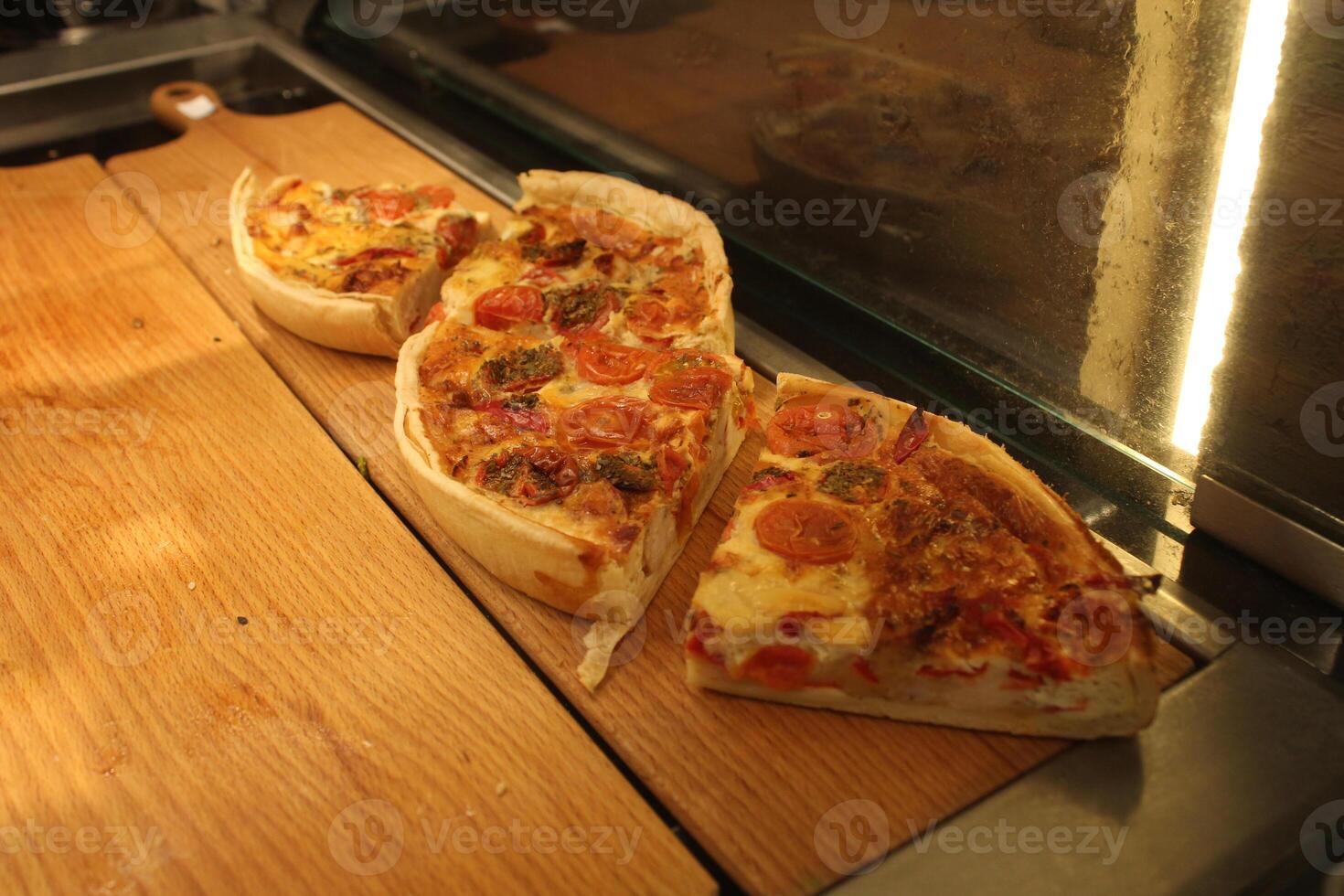 Quiche pie with meat filling cut into portions on the display case photo