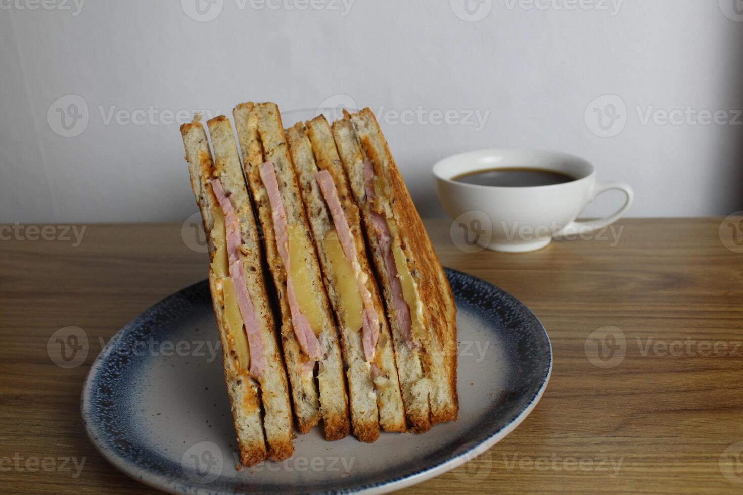 Food, breakfast Sandwiches with ham cheese and vegetable elenium lie on a gray plate next to the juice of orange apricot on the table. Cooking breakfast photo