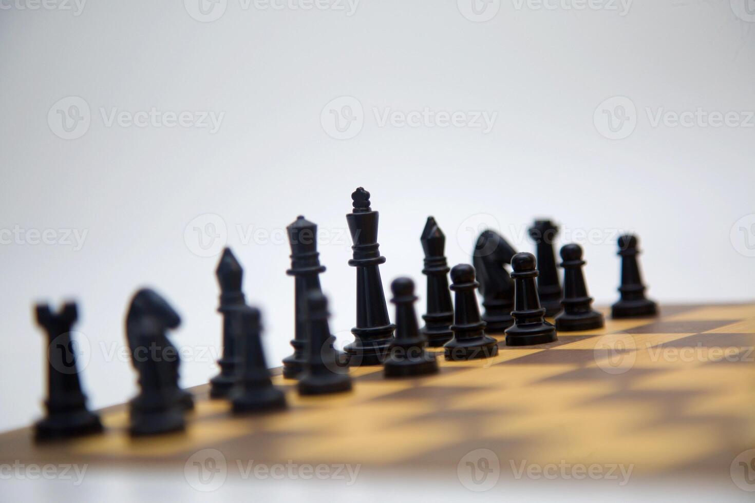 Chessboard setting,The Black King leads his army into the battlefield.The Black King leads his Army. A view of a chessboard with black pieces arranged in a strategic formation. photo