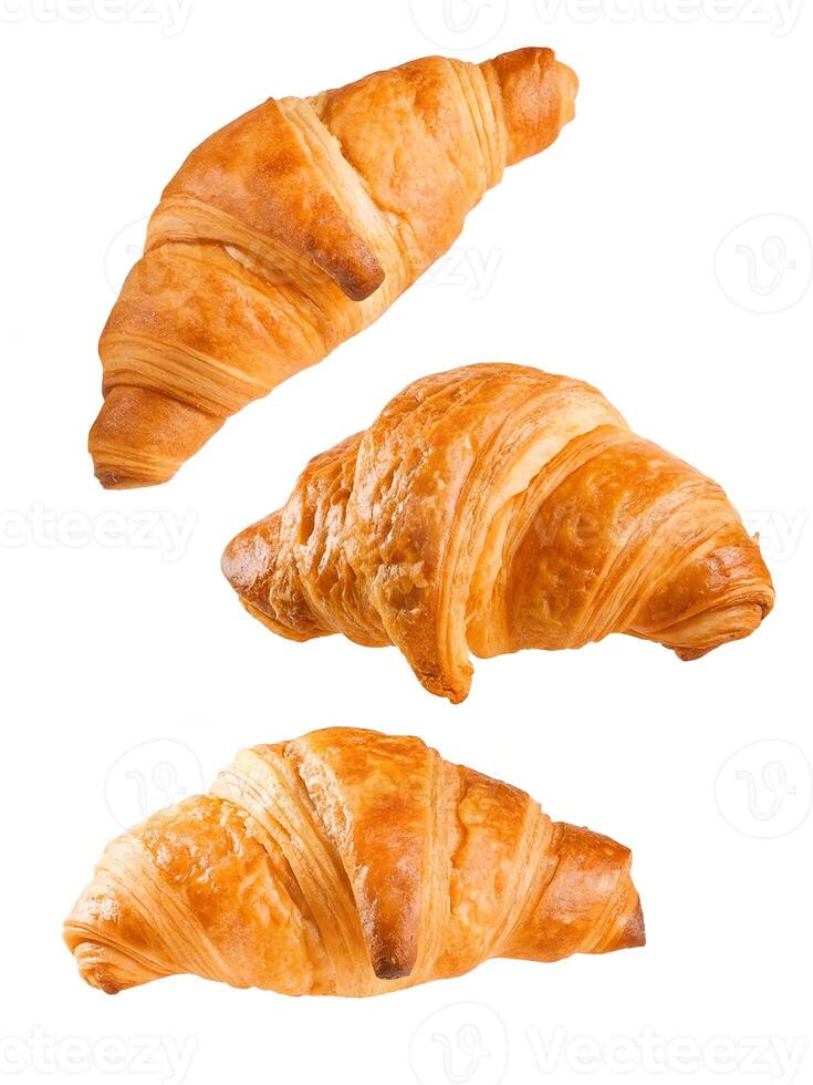 Three golden brown croissants artfully arranged against a clean white background, showcasing their flaky layers and inviting texture. photo