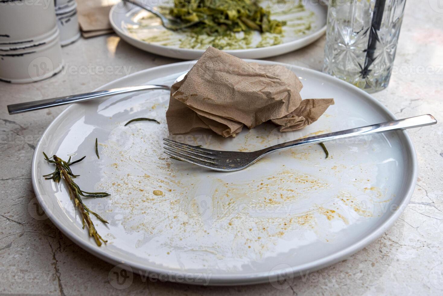 Empty plates after a meal at a modern restaurant with clean tableware and remnants of food photo