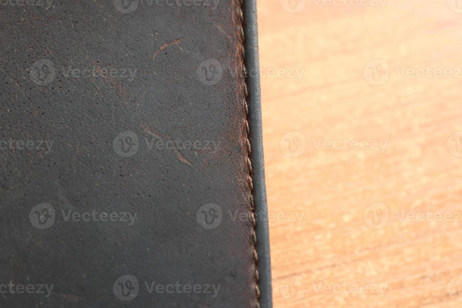 This is a CloseUp Image of a Dark Leather Surface Showcasing Intricate Stitching and Details photo